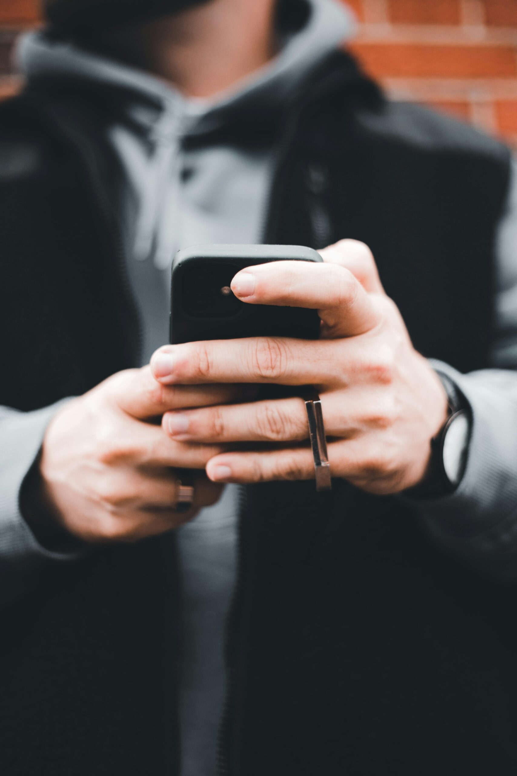 Close-up of hands holding an iPhone, representing direct email marketing.