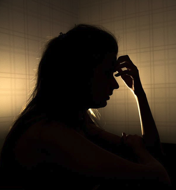 Silhouette of a woman with her hand on her forehead, exuding confusion and emotional overwhelm.